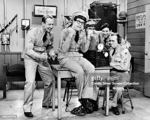 Sergeant Ernie Bilko, played by American comedian Phil Silvers , and Corporal Steve Henshaw, played by Allan Melvin celebrate good news in the US TV...