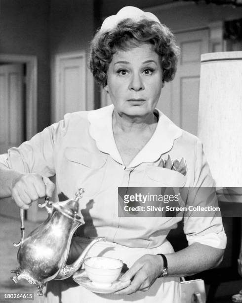 American actress Shirley Booth pouring tea from a pot, as the maid, Hazel Burke, in the US sitcom 'Hazel', circa 1964.