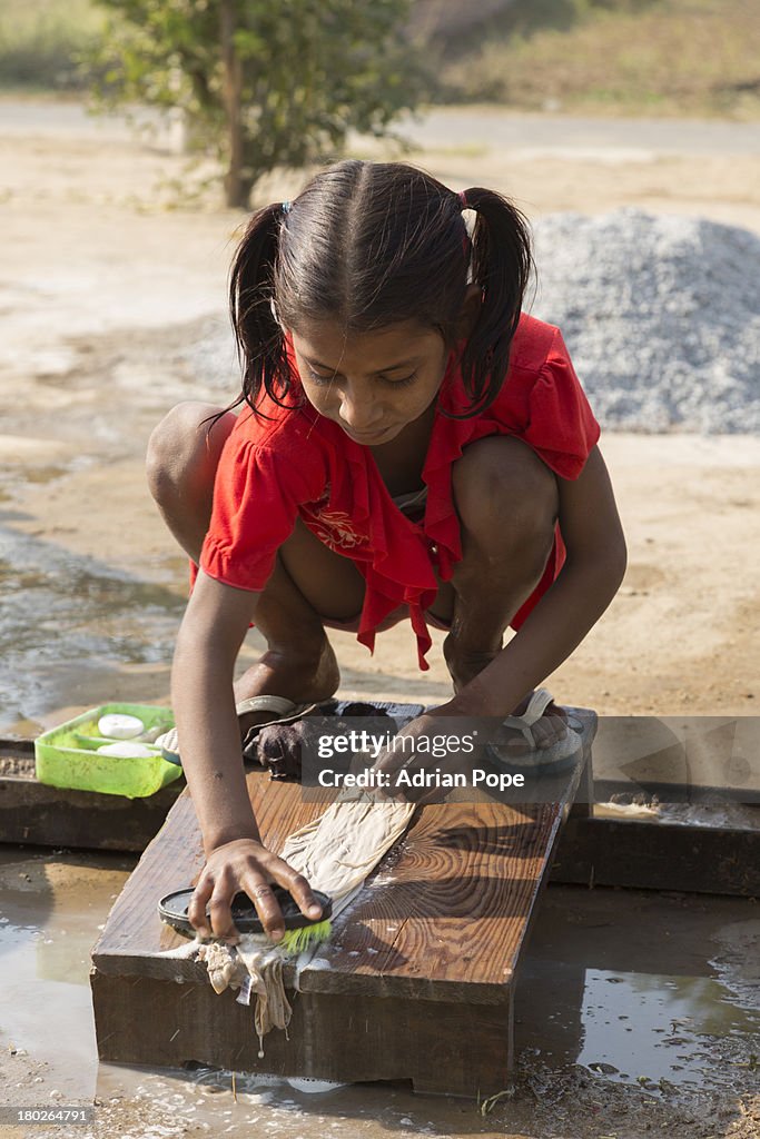 Young Indian girl washing clothes by hand