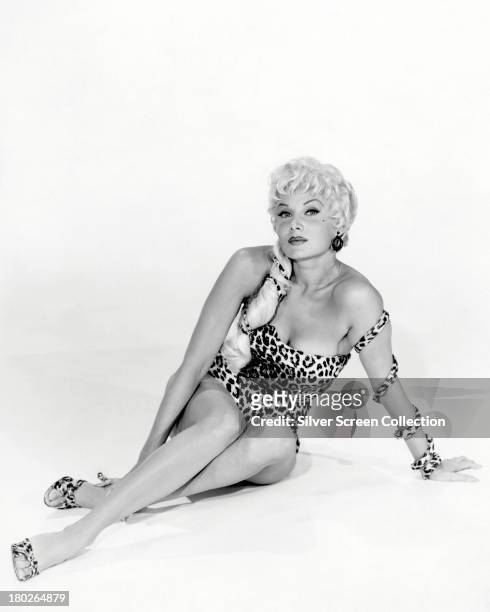 American actress Rhonda Fleming posing in a one-piece leopard-print swimsuit, circa 1955.