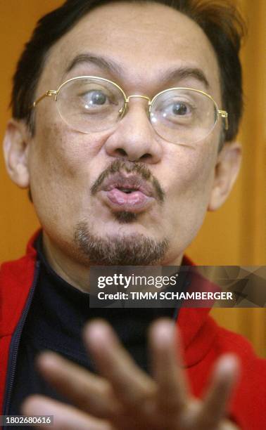 Former Malaysian deputy Prime Minister Anwar Ibrahim gestures as he speaks to journalists in his room at the Alpha Clinic in Munich 20 September...