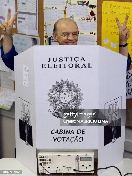 Sao Paulo's mayor candidate Jose Serra, of Social Democracy Party , flashes the sign of victory as he casts his vote in an electronic voting machine,...