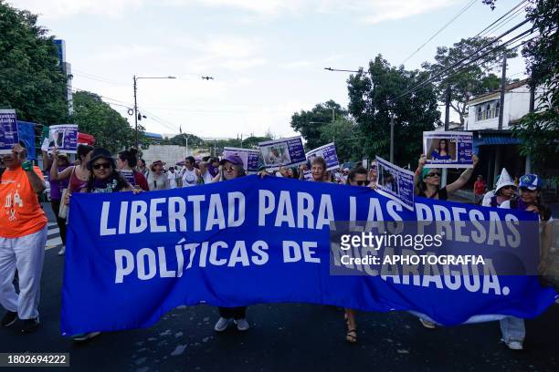 Women of feminist organizations in Nicaragua carry a banner and posters during a demonstration to mark International Day For The Elimination Of...