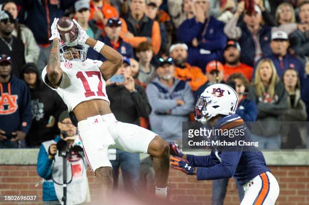 Wide receiver Isaiah Bond of the Alabama Crimson Tide catches a pass for a touchdown in front of cornerback D.J. James of the Auburn Tigers during...