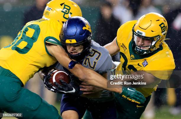 Preston Fox of the West Virginia Mountaineers is tackled by Dylan Schaub and Micah Gifford of the Baylor Bears and during the first half at McLane...