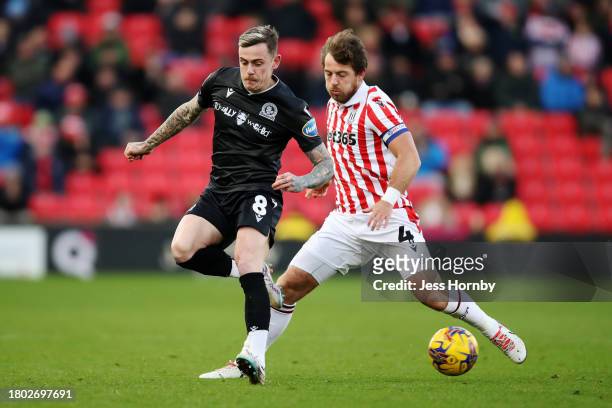 Sammie Szmodics of Blackburn Rovers passes the ball under pressure from Ben Pearson of Stoke City during the Sky Bet Championship match between Stoke...