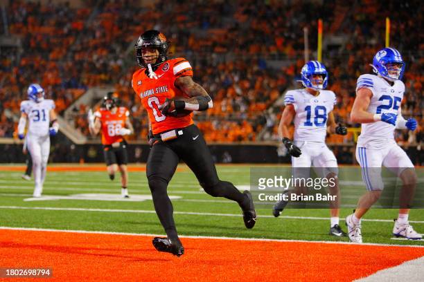 Running back Ollie Gordon II of the Oklahoma State Cowboys sticks out his tongue after scoring a go-ahead touchdown against the BYU Cougars late in...