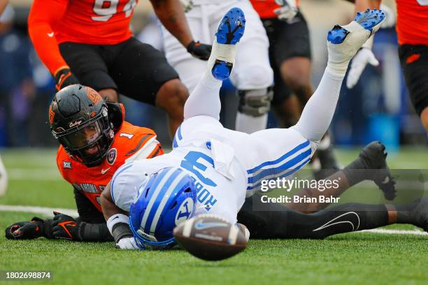 Running back Aidan Robbins of the BYU Cougars fails to catch a pitch from quarterback Jake Retzlaff against linebacker Xavier Benson of the Oklahoma...