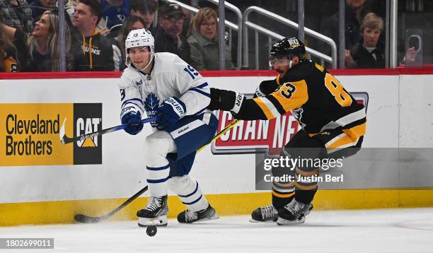 Calle Jarnkrok of the Toronto Maple Leafs moves the puck against Matt Nieto of the Pittsburgh Penguins in the third period at PPG PAINTS Arena on...