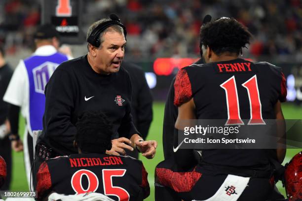 San Diego State head coach Brady Hoke talks with the offense in the bench area during a college football game between the Fresno State Bulldogs and...