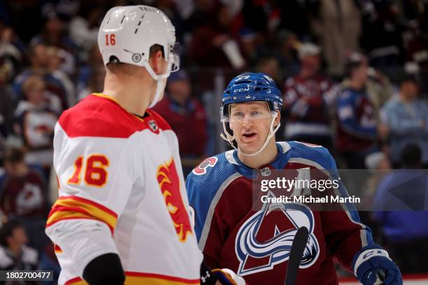 Nikita Zadorov of the Calgary Flames talks with Nathan MacKinnon of the Colorado Avalanche during a pause in play at Ball Arena on November 25, 2023...