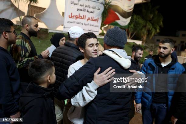 Palestinians, brought by International Committee of the Red Cross vehicle, reunite with their relatives as they are released from Israeli Ofer prison...