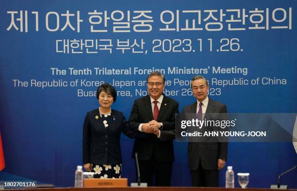 Japanese Foreign Minister Yoko Kamikawa, South Korean Foreign Minister Park Jin, and Chinese Foreign Minister Wang Yi pose for a photo prior to the...