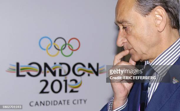 Paris Mayor Bertrand Delanoe looks pensive as he walks past a London 2012 display in Singapore 05 July 2005. The 117th IOC session will elect 06 July...