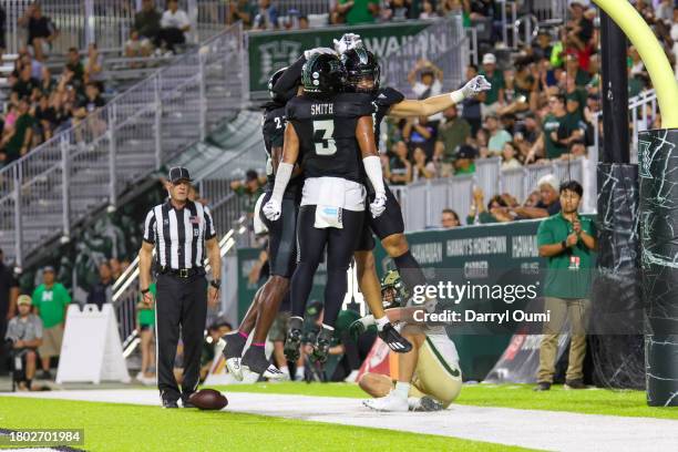 Virdel Edwards II, Jalen Smith and Noah Kema of the Hawaii Rainbow Warriors celebrate after denying a two point conversion during the second half of...