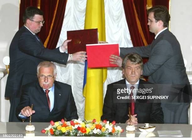 Assistances change folders with documents after Czech President Vaclav Klaus and Ukraine's President Viktor Yushchenko signed them at the Mareensky...