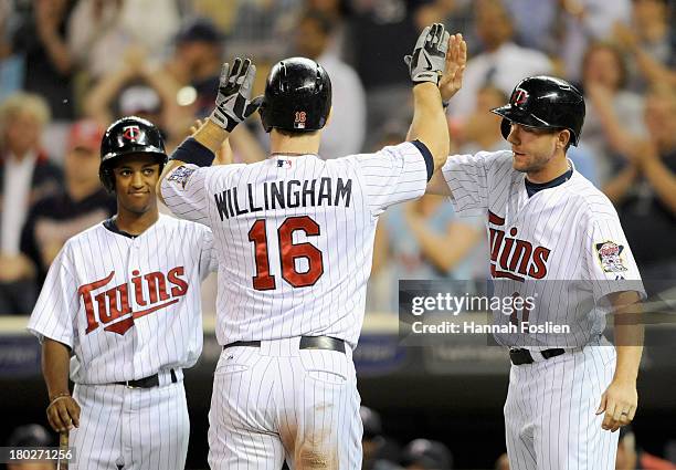 Clete Thomas of the Minnesota Twins congratulates teammate Josh Willingham on a two run home run against the Oakland Athletics during the eighth...