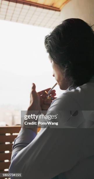 asian man smokes cigarette - myocarditis stock pictures, royalty-free photos & images