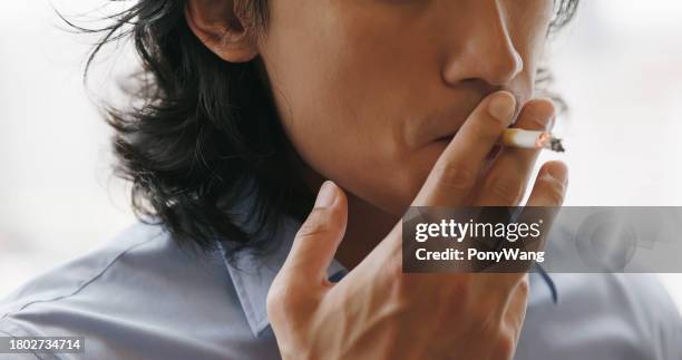 asian man smokes cigarette - myocarditis stock pictures, royalty-free photos & images