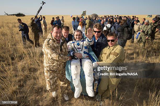 In this handout provided by NASA, Expedition 36 Commander Pavel Vinogradov of the Russian Federal Space Agency is carried to the medical tent shortly...