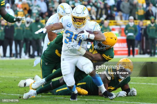 Austin Ekeler of the Los Angeles Chargers runs with the ball while being tackled by Corey Ballentine of the Green Bay Packers in the fourth quarter...