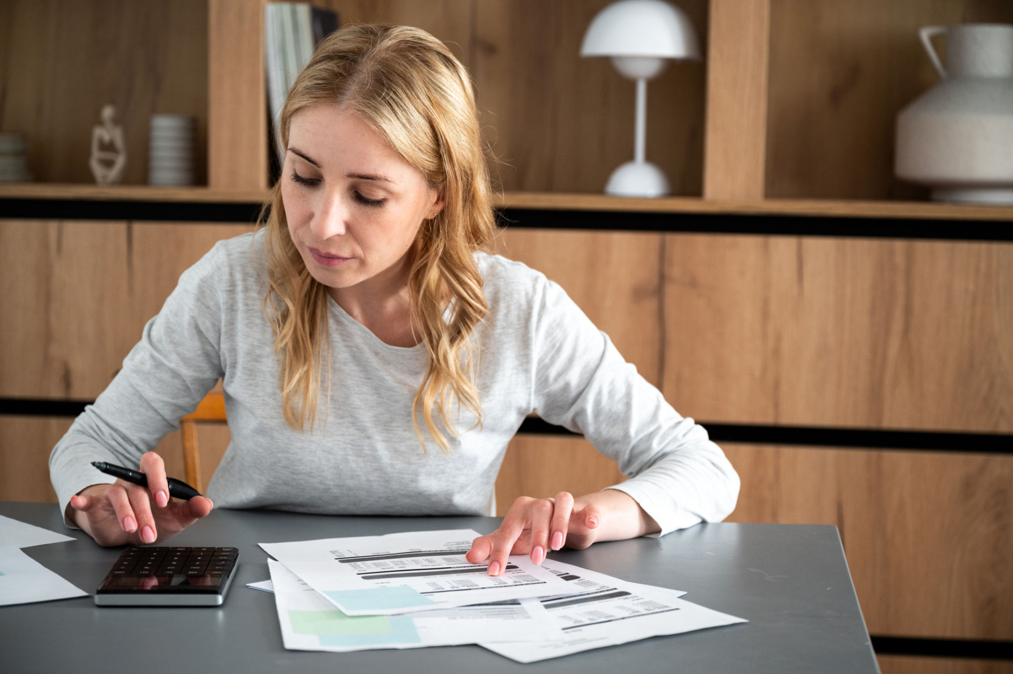 Woman calculate utility bills, checking household finances or taxes on machine Woman calculate utility bills, checking household finances or taxes on machine