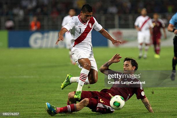 Paolo Hurtado of Peru competes for the ball with Fernando Amorebieta of Venezuela during a match between Venezuela and Peru as part of the 16th round...
