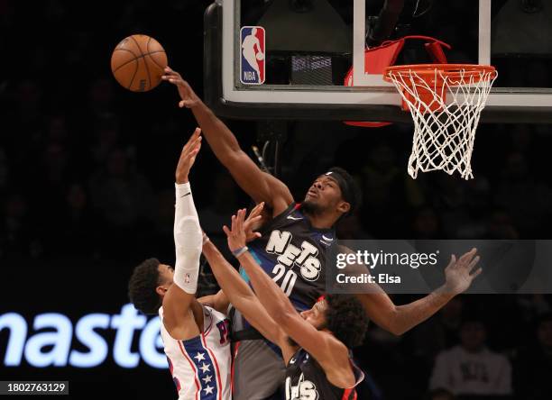 Royce O'Neale of the Brooklyn Nets blocks a shot by Tobias Harris of the Philadelphia 76ers as Spencer Dinwiddie of the Brooklyn Nets defends in the...