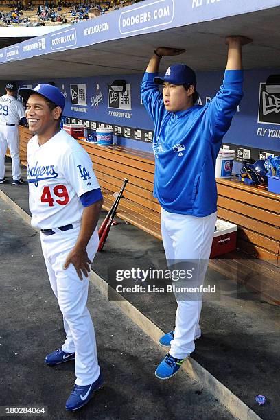 Carlos Marmol and Hyun-Jin Ryu of the Los Angeles Dodgers stand in the dugout before the game against the Arizona Diamondbacks at Dodger Stadium on...