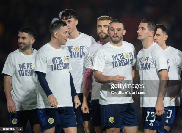 John McGinn, Callum McGregor and Kenny McLean of Scotland wear shirts reading WE'RE OFF TO GERMANY after the UEFA EURO 2024 European qualifier match...