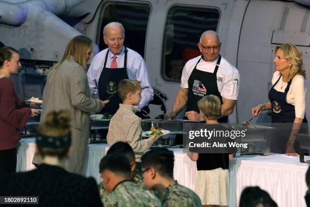 President Joe Biden, chef Robert Irvine, and first lady Jill Biden serve service members and military families from the USS Dwight D. Eisenhower and...