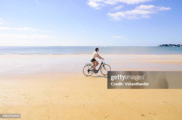 woman cycling on the beach early in the morning - loire atlantique 個照片及圖片檔