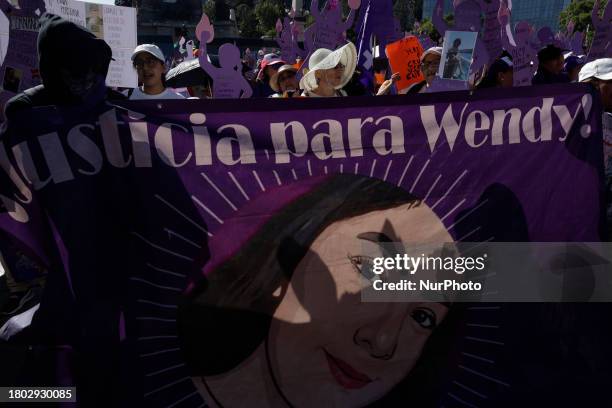 Mothers of missing daughters, victims of feminicide, and those affected by sexist violence are holding a blanket while demonstrating at the Angel of...