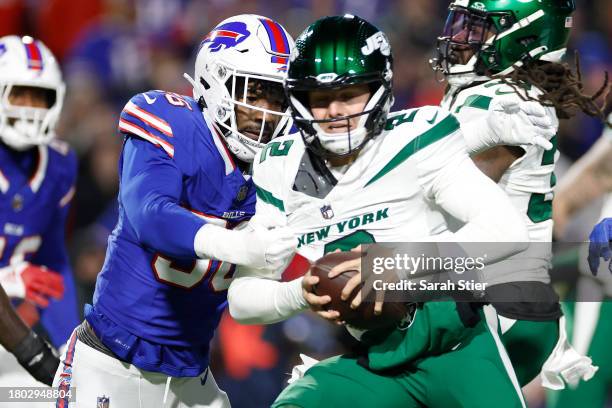 Zach Wilson of the New York Jets drops back to pass while being pressured by Leonard Floyd of the Buffalo Bills in the second quarter at Highmark...