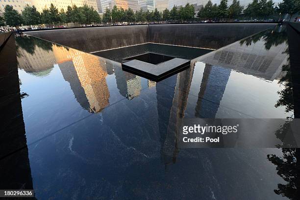 Building are reflected in one of the pools of the 9/11 Memorial during ceremonies for the twelfth anniversary of the terrorist attacks on lower...