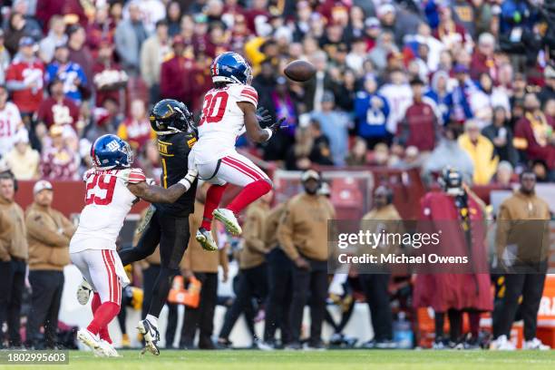 Darnay Holmes of the New York Giants intercepts a pass intended for Jahan Dotson of the Washington Commanders during an NFL football game between the...