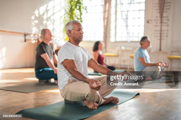 a diverse yoga class for health and wellness - senior yoga stock pictures, royalty-free photos & images