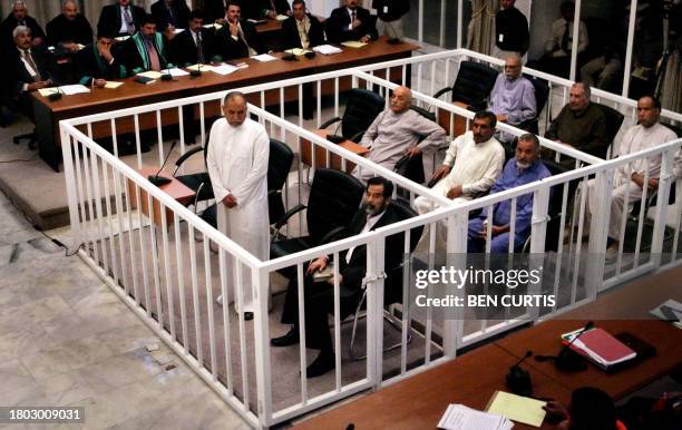File picture dated 19 October 2005 shows defendants in first row of cages, left to right, Awad Hamad Al-Bandar, Saddam Hussein; Second row of cages,...