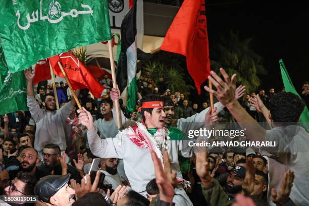 Palestinians prisoners cheer among supporters after being released from Israeli jails in exchange for hostages released by Hamas from the Gaza Strip,...