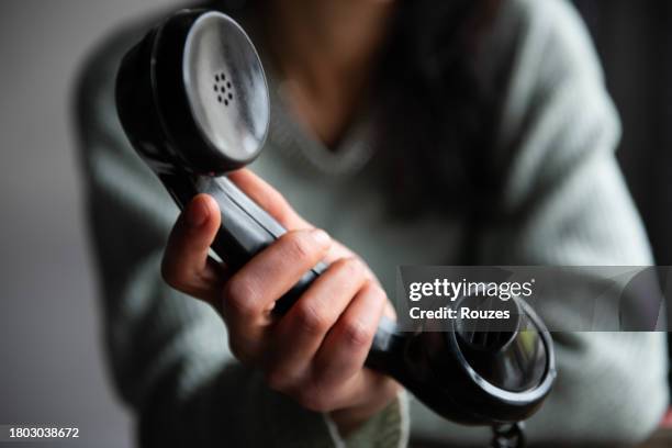 woman's hand holding a vintage telephone - handset hand stock pictures, royalty-free photos & images