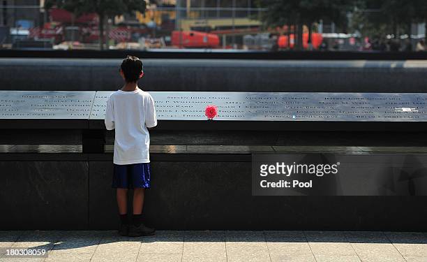 Boy looks at names on the South reflecting pool at the 9/11 Memorial during ceremonies marking the 12th anniversary of the 9/11 attacks on the World...