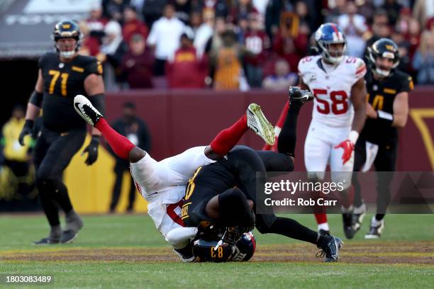 Wide receiver Jamison Crowder of the Washington Commanders is tackled by cornerback Darnay Holmes of the New York Giants after catching a pass at...