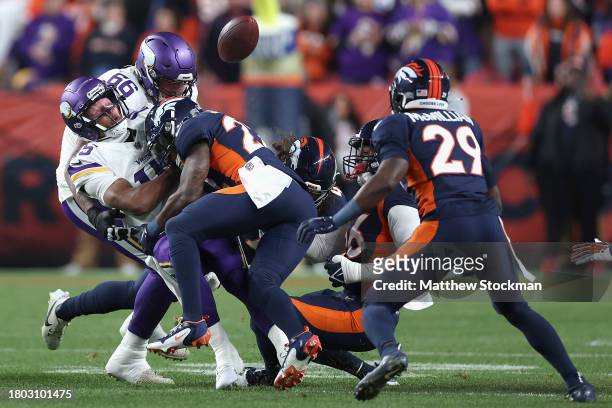 Quarterback Joshua Dobbs of the Minnesota Vikings fumbles the football after being hit by safety Kareem Jackson of the Denver Broncos during the...