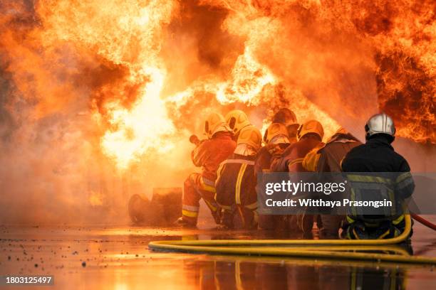 firefighter spraying water at a house fire - feuerwehrschlauch stock-fotos und bilder