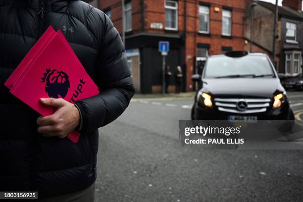 Member of the 1878s, Everton's supporter group, distributes leaflets reading "Corrupt" next to the Premier League logo, to protest over the club...