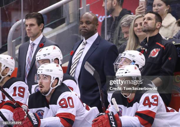Assistant coaches Rick Kowalsky and Mike Grier of the New Jersey Devils look on from behind the bench as Travis Zajac and Taylor Hall and Marcus...