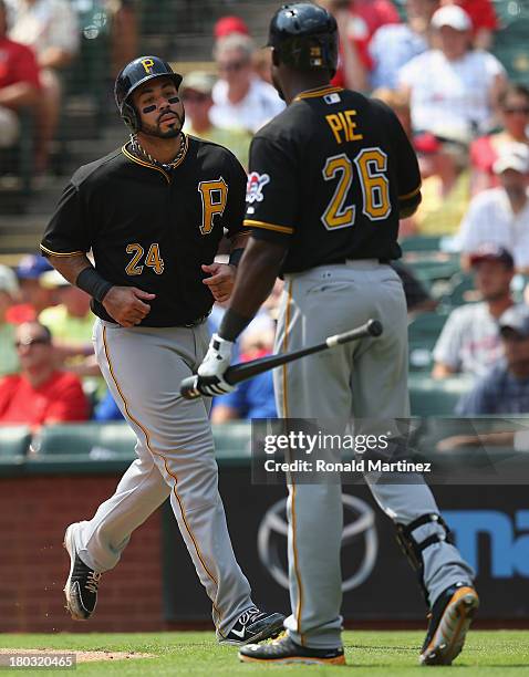 Pedro Alvarez of the Pittsburgh Pirates celebrates a run with Felix Pie against the Texas Rangers at Rangers Ballpark in Arlington on September 11,...