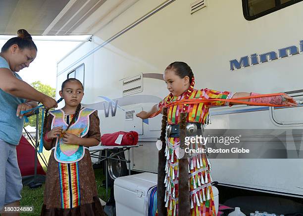 Bear Bear Laughing, from Akwesasne, N.Y., left, helps her daughters Noelani Wilson center, and Isabelle Wilson prepare to take part in the 92nd...