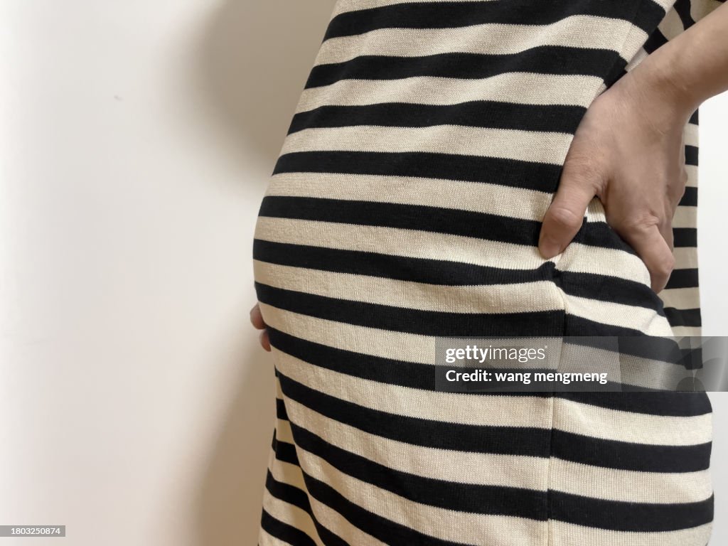 A skinny pregnant woman strokes her belly