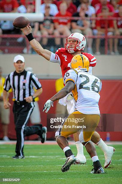 Quarterback Taylor Martinez of the Nebraska Cornhuskers throws over defensive back Debarriaus Miller of the Southern Miss Golden Eagles during their...